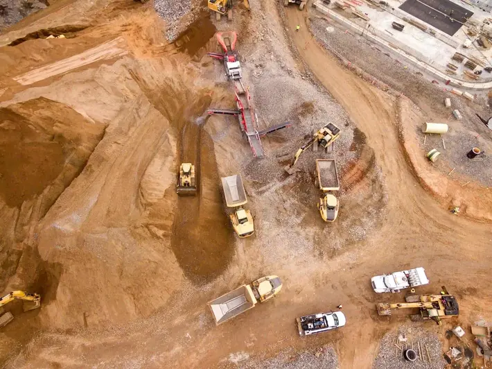 Aerial view of dump trucks and earthmoving equipment on a construction site